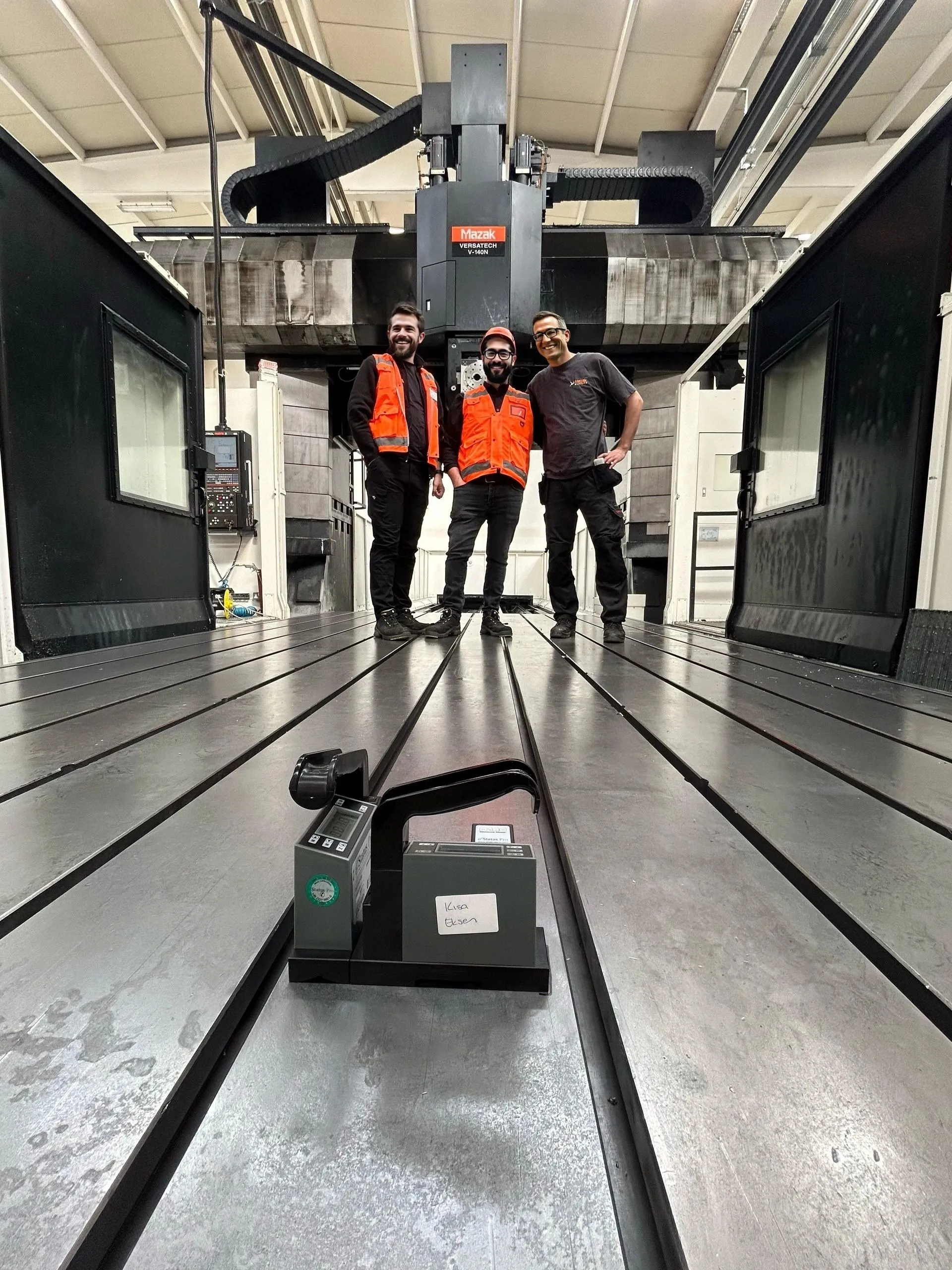 Our team on the table of a gantry machine being measured with a digital level